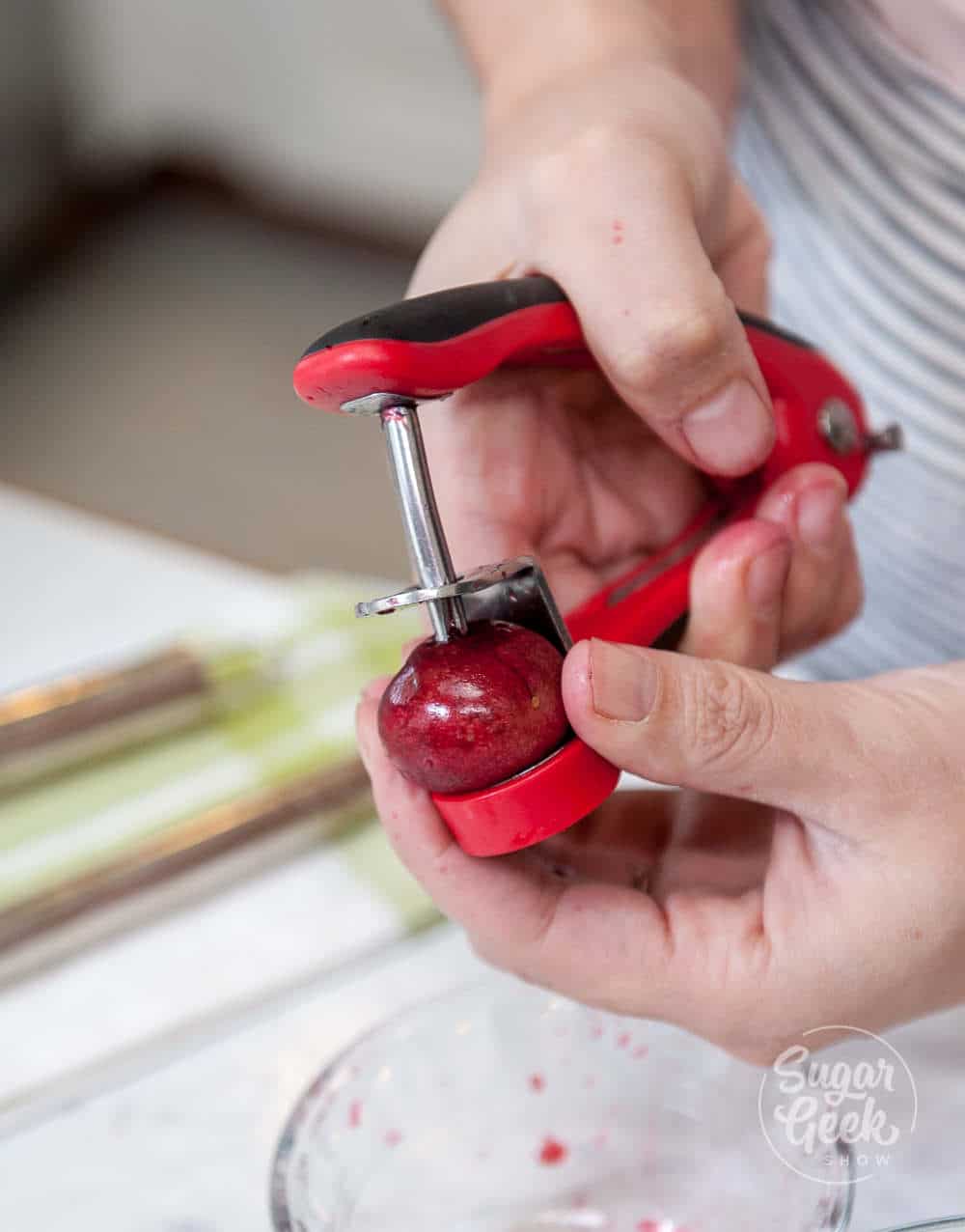 using a cherry pitter to remove the pit from cherries