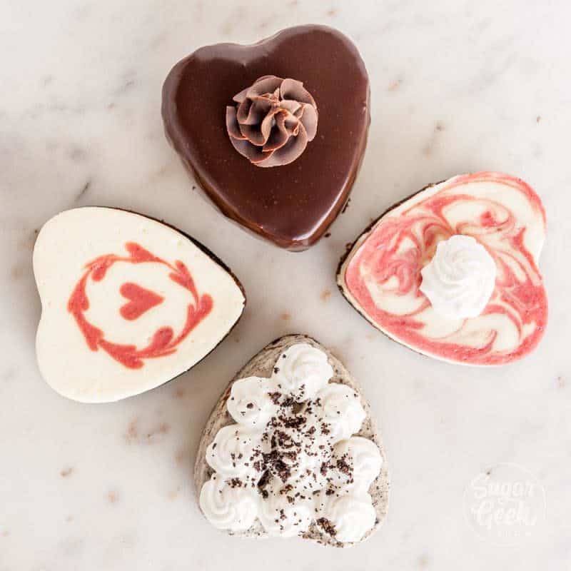 four mini heart cheesecakes on a marble background