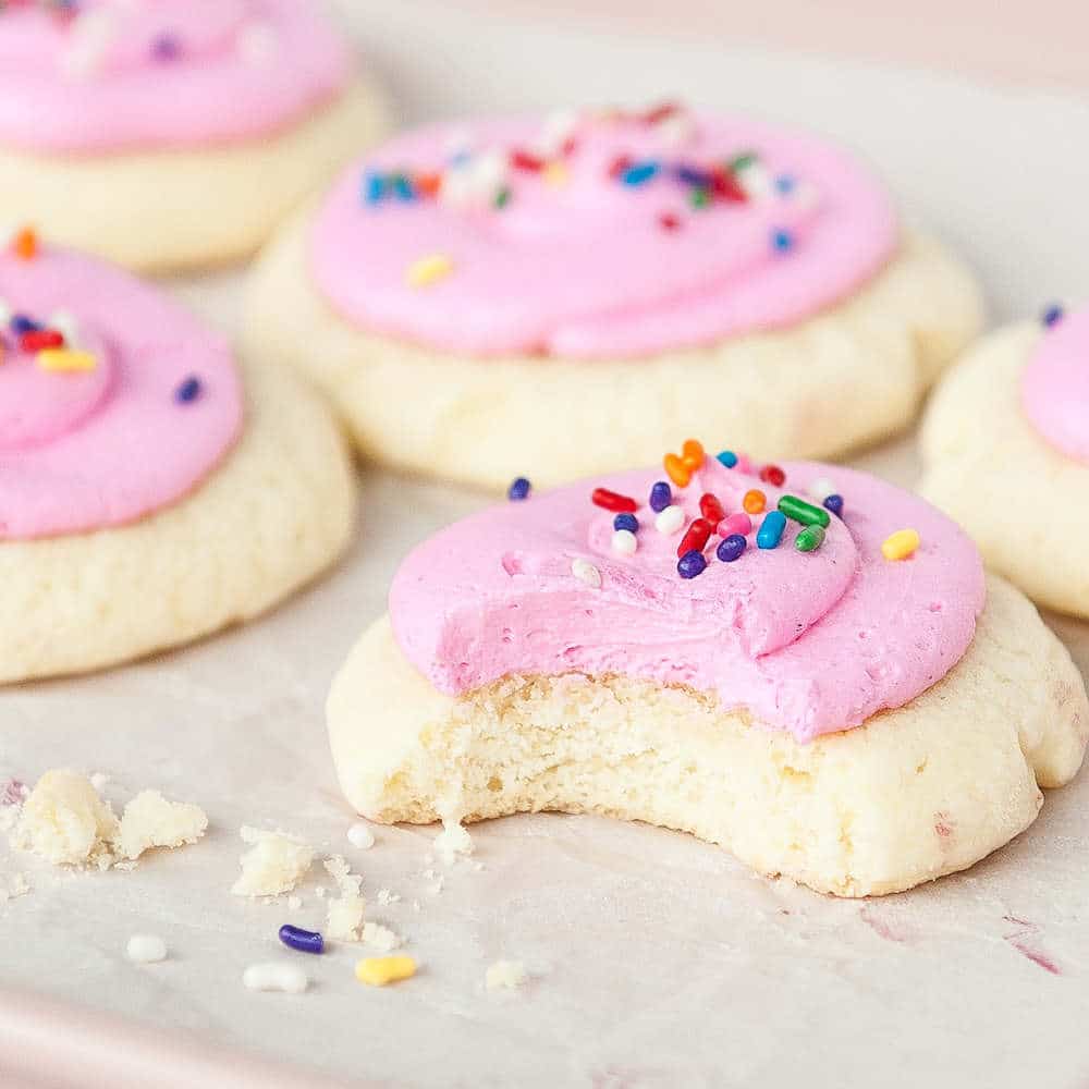 lofthouse cookies on white parchment paper. Bite taken out of one cookie