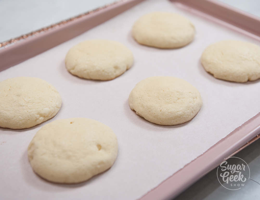 freshly baked lofthouse cookies on a parchment lined baking tray