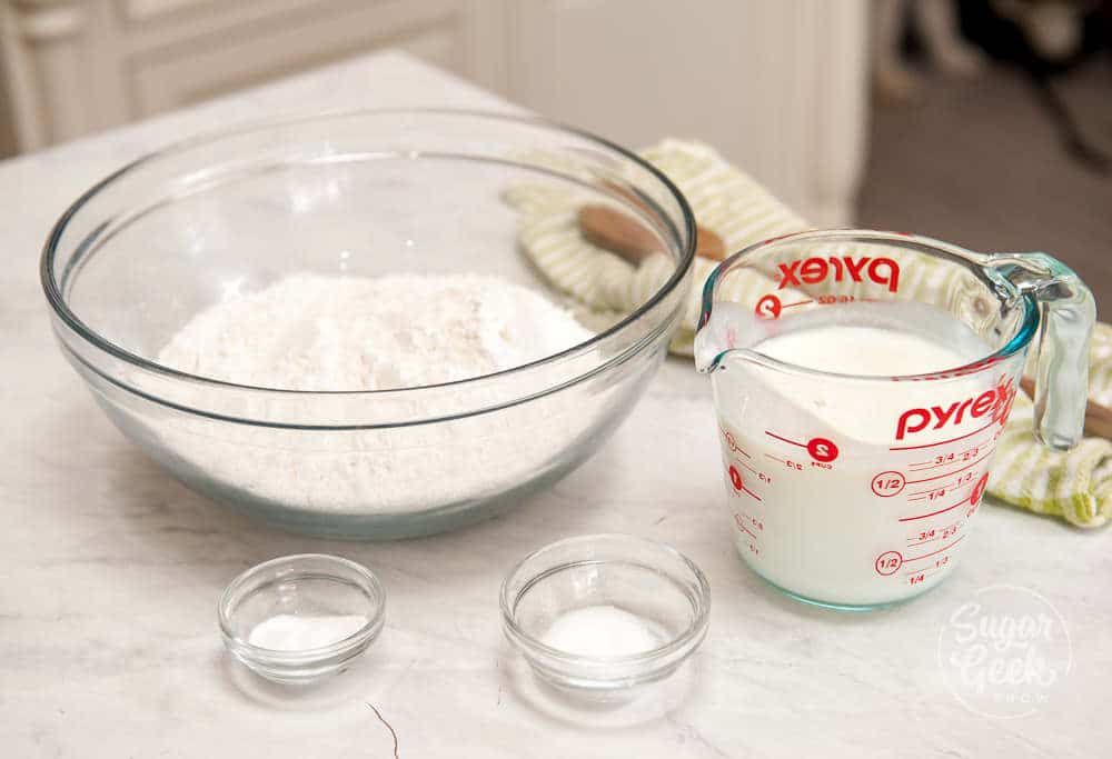 traditional irish soda bread ingredients in clear bowls and a measuring cup