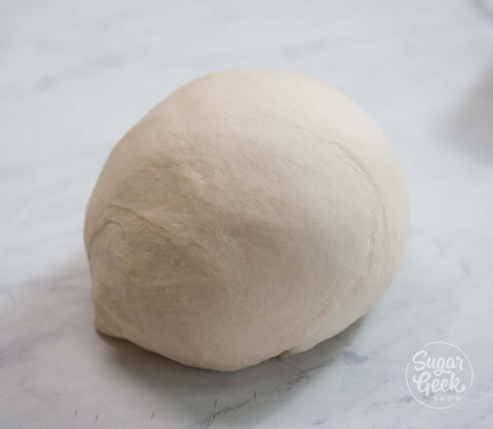 close up of a smooth ball of dough on a workbench