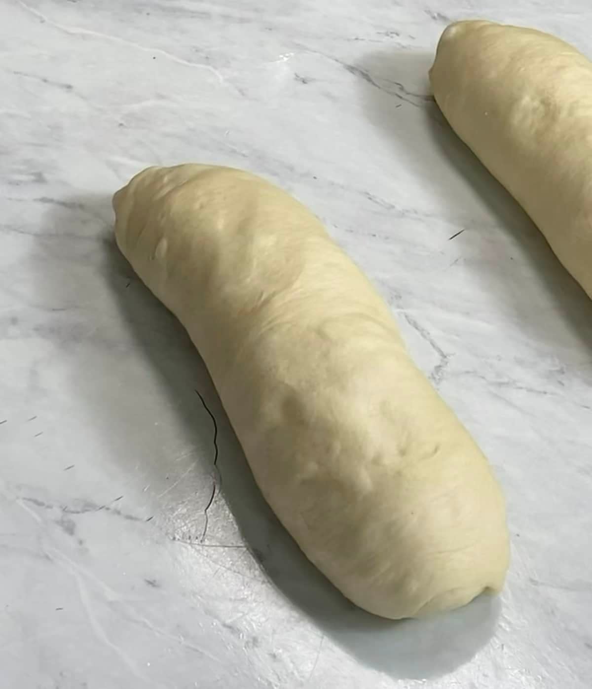 Shaped bread dough on a white countertop.