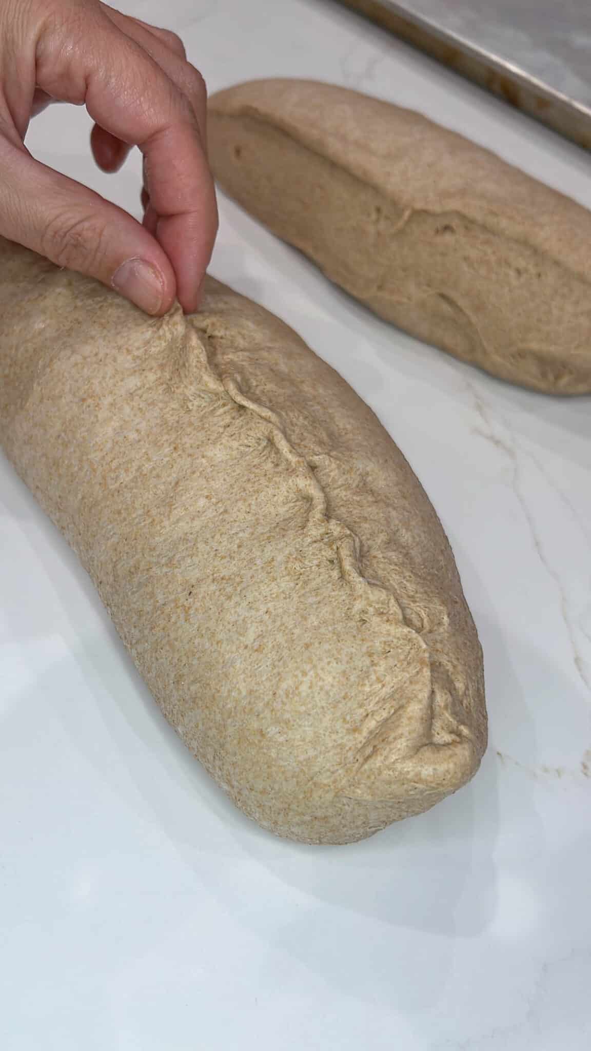 close up of hand pinching and shaping dough