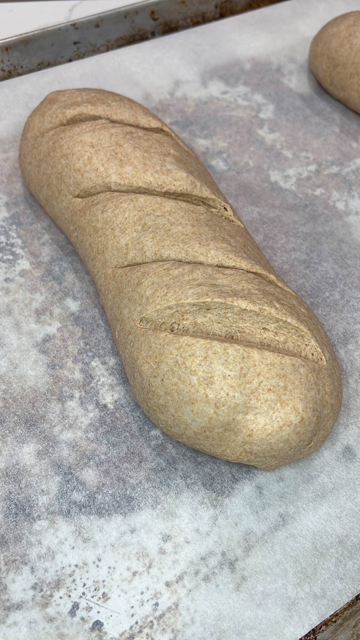 close up of unbaked bread loaf cut with a knife