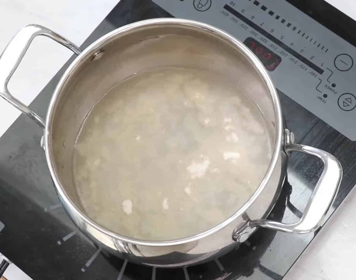 Agar agar powder blooming in water inside a saucepan.