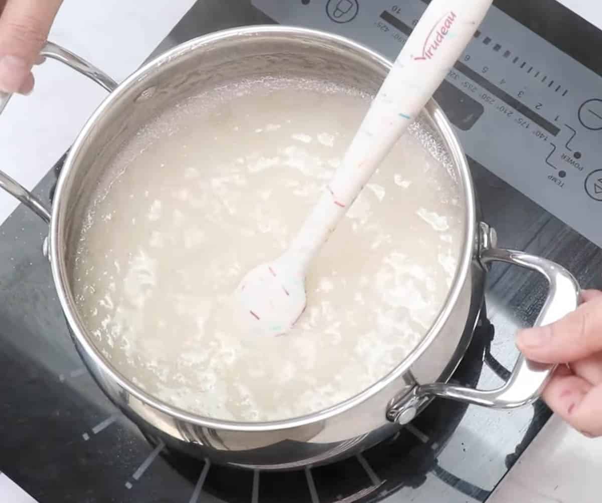 Saucepan with simmering kohakutou mixture inside with a rubber spatula.