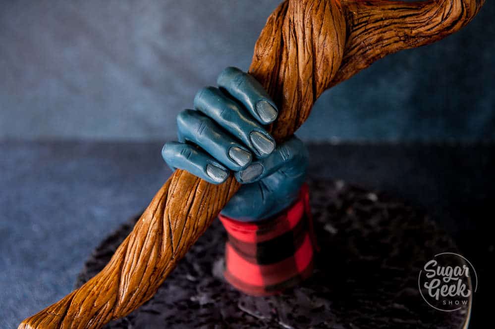 close up of modeling chocolate hand holding wizard staff