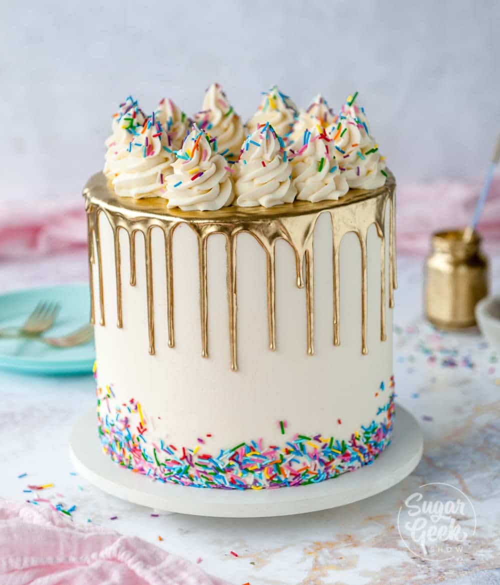 rainbow cake with gold drip and rainbow sprinkles