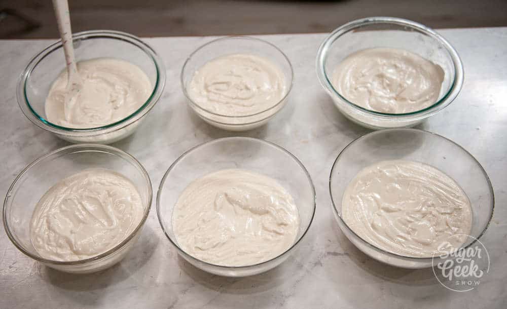 6 bowls of white velvet cake ready to be colored