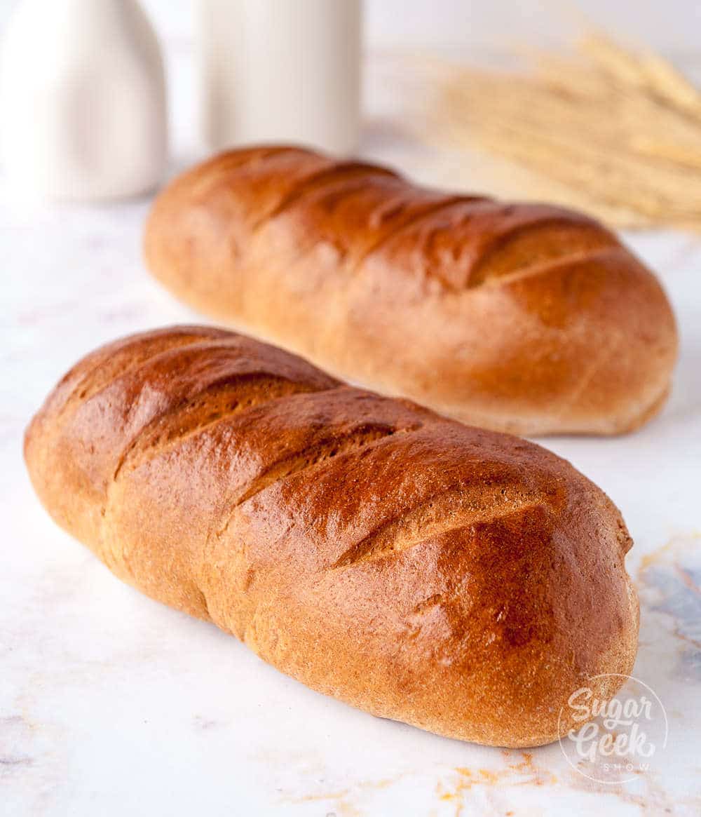 two loaves of whole wheat bread on a white background