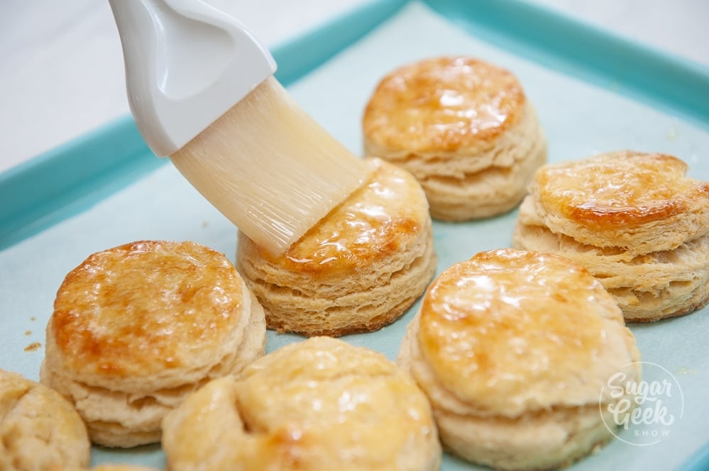 freshly made buttermilk biscuits being brushed with melted butter