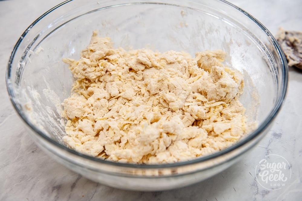 loose biscuit dough in clear bowl on white countertop