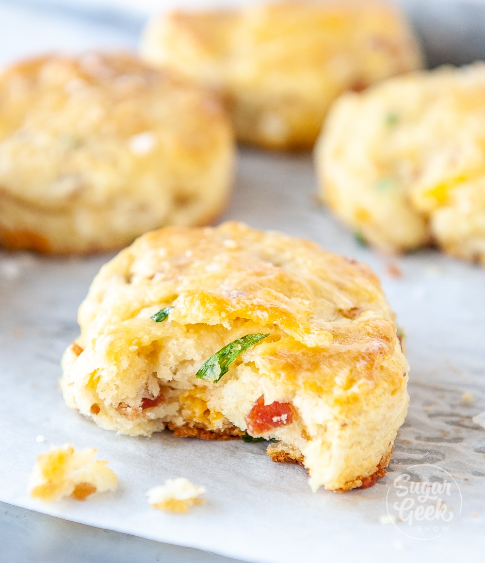 close up image of bacon cheddar chive biscuit with bite taken out of it