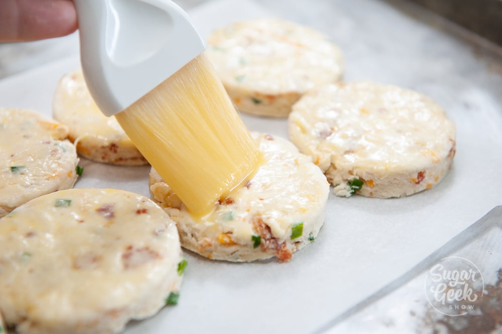 brushing bacon cheddar chive biscuits with egg wash