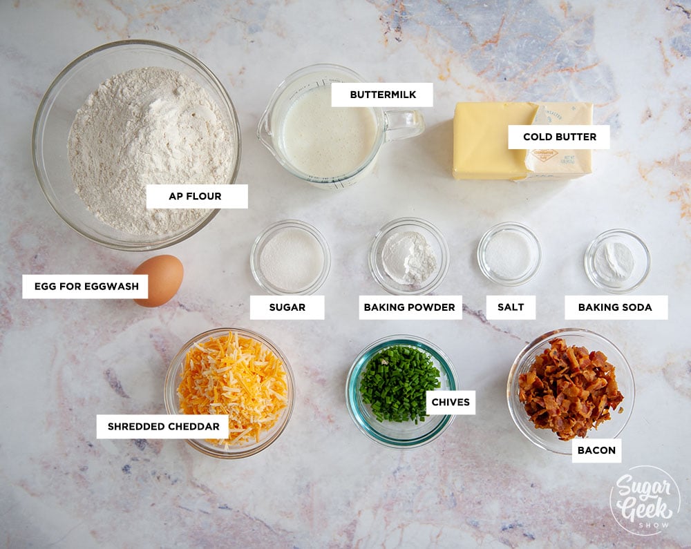 ingredients needed to make bacon cheddar chive biscuits in clear bowls shot from above