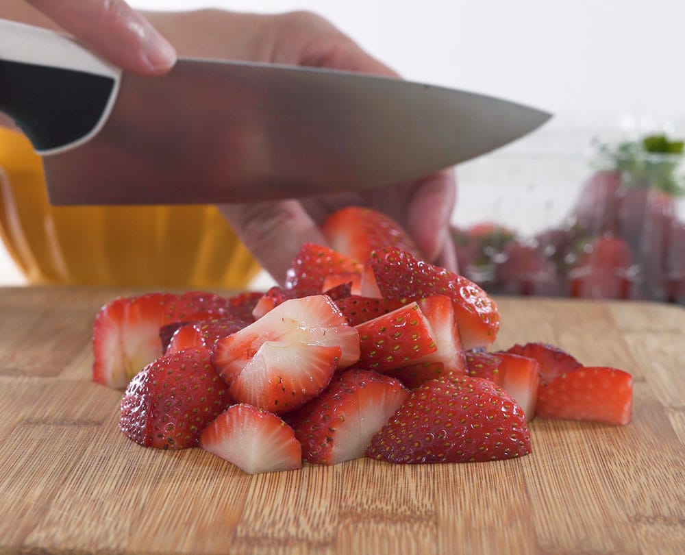 Close Up of Strawberry Slices on a Wooden Cutting Board