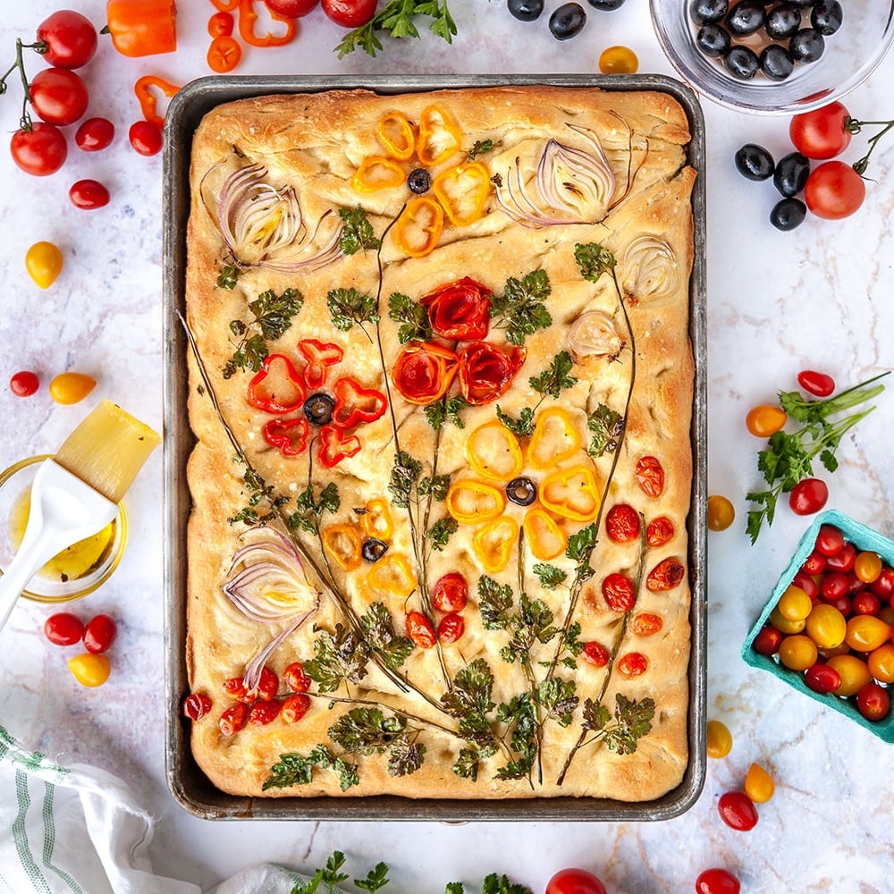 focaccia bread decorated with vegetables to look like flowers shot from above
