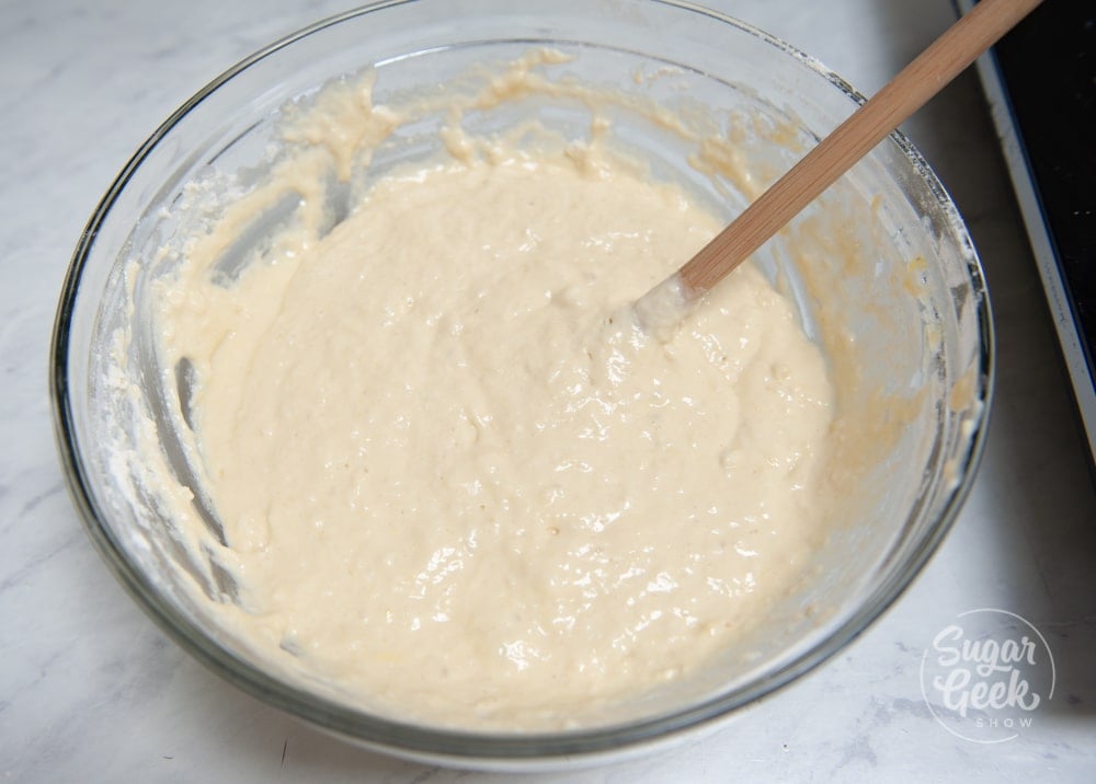 sourdough pancake batter in a clear bowl with a wooden spoon
