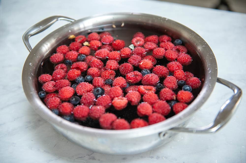 berries in mixture of water and vinegar in metal pot