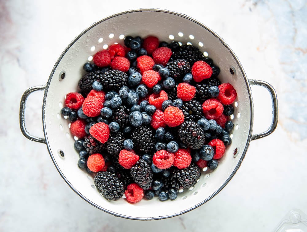 mixed berries in white colander