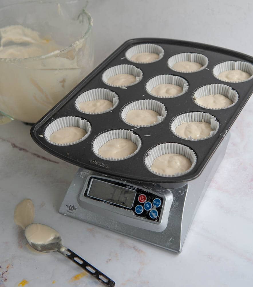 adding cupcake batter to cupcake pan on scale