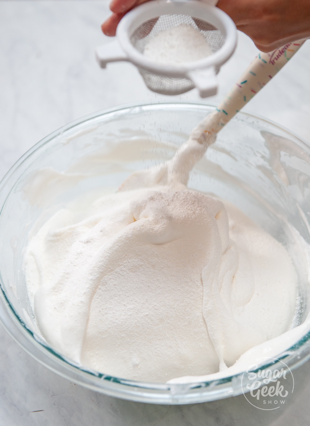 sifting flour into meringue mixture