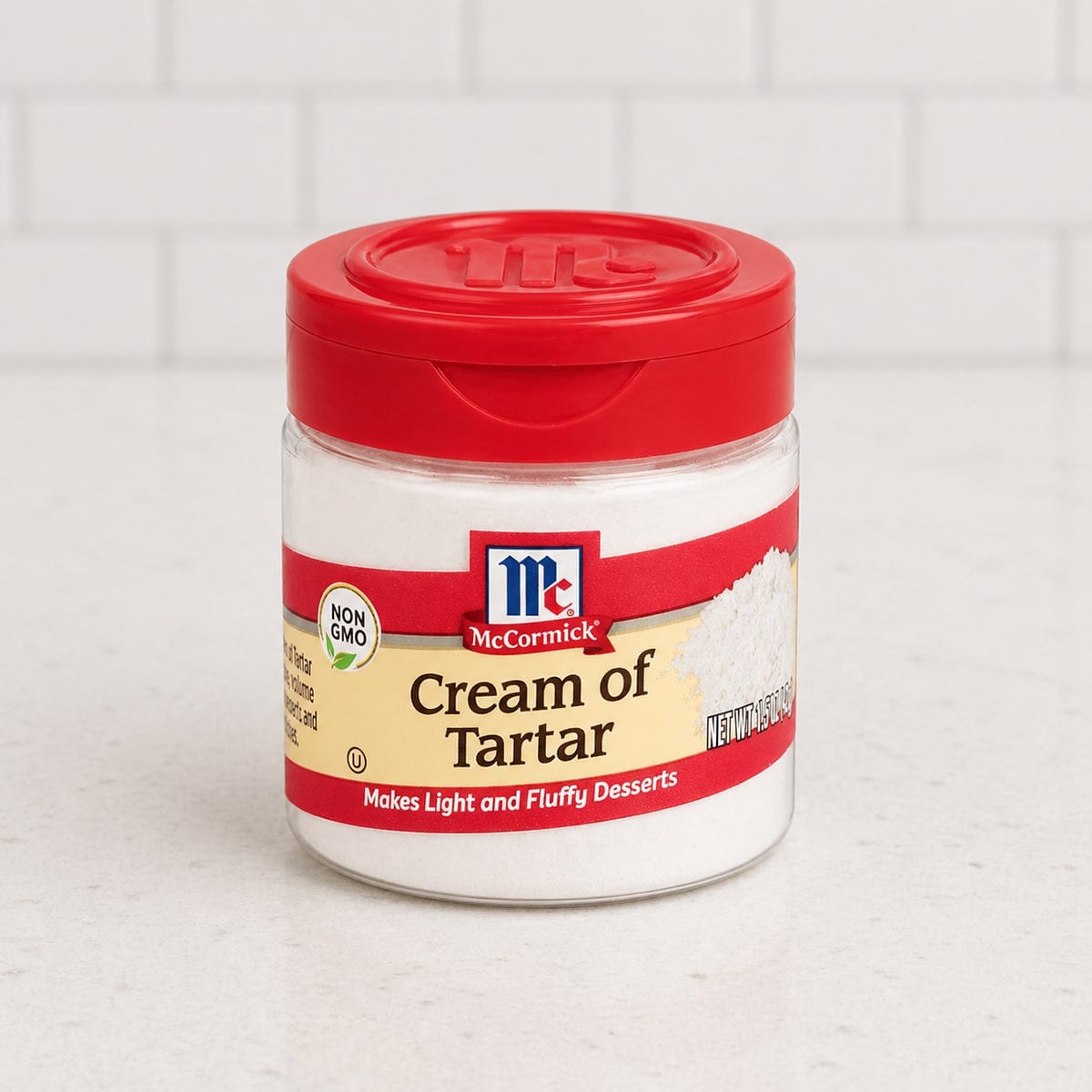 Container of cream of tartar on a white countertop.