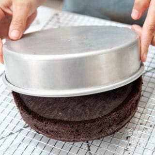 chocolate cake coming out of the pan onto a cooling rack