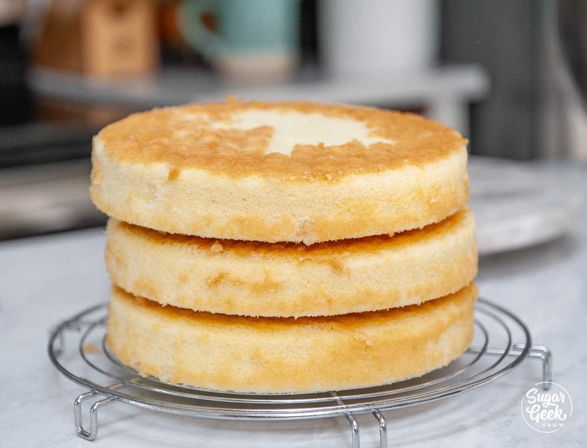 stack of vanilla cake layers on a cooling rack