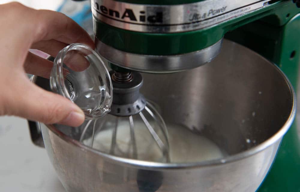 holding clear glass bowl above the rim of a metal bowl mixer