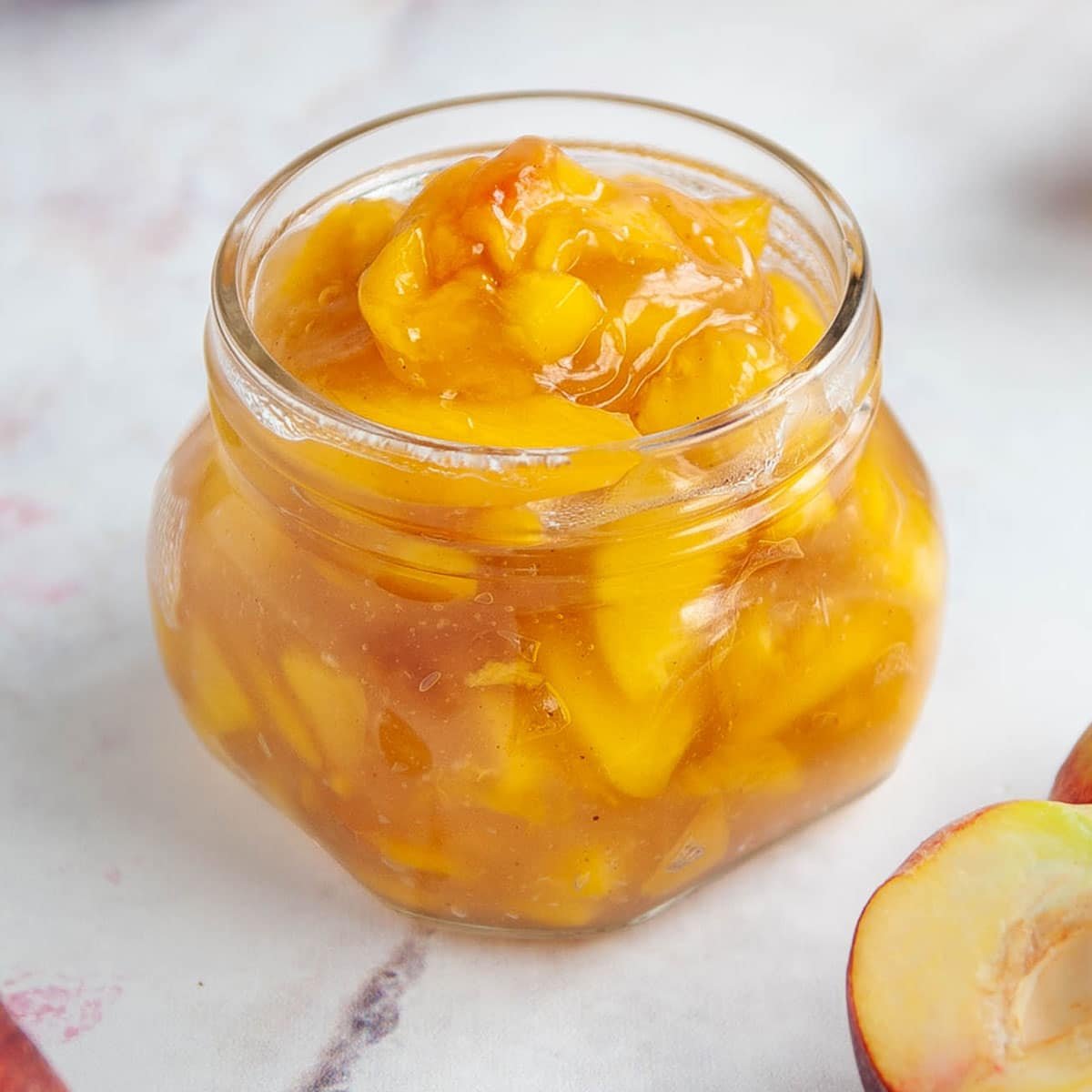 close up of peach filling in a small glass jar
