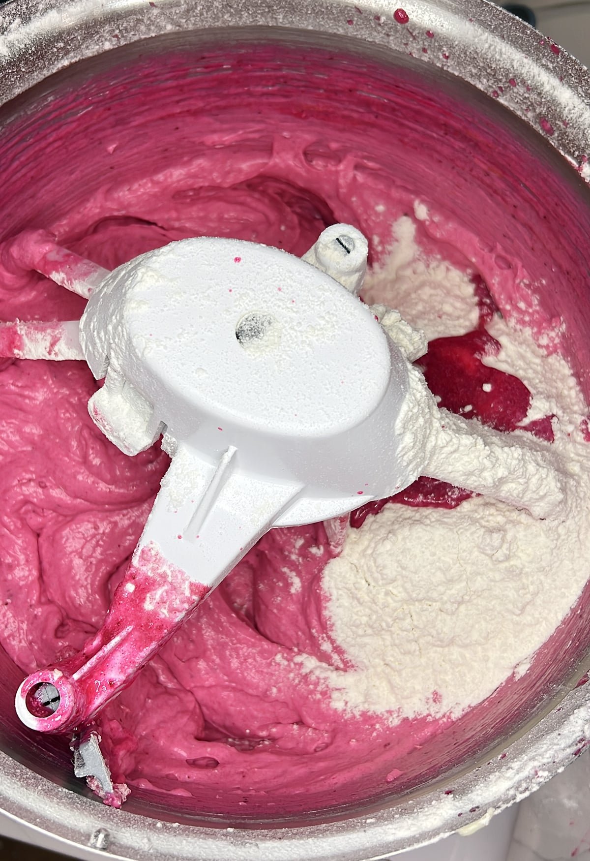 close up of strawberry cake batter being mixed in the bowl