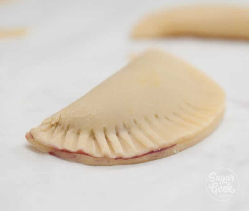 Crimping the edge of a hand pie with a fork.