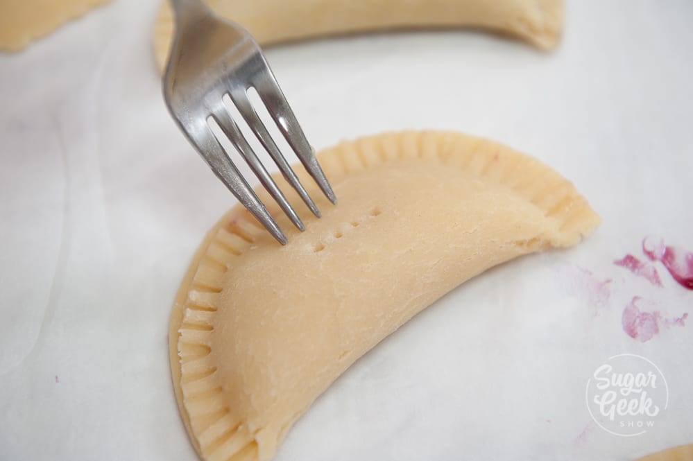 crimping the edge of a hand pie with a fork