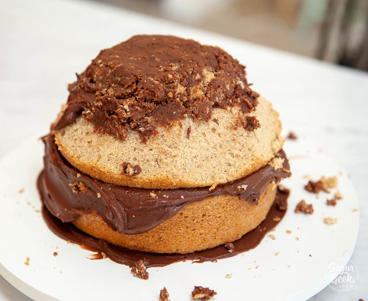 two cakes carved into a dome with some ganache on top