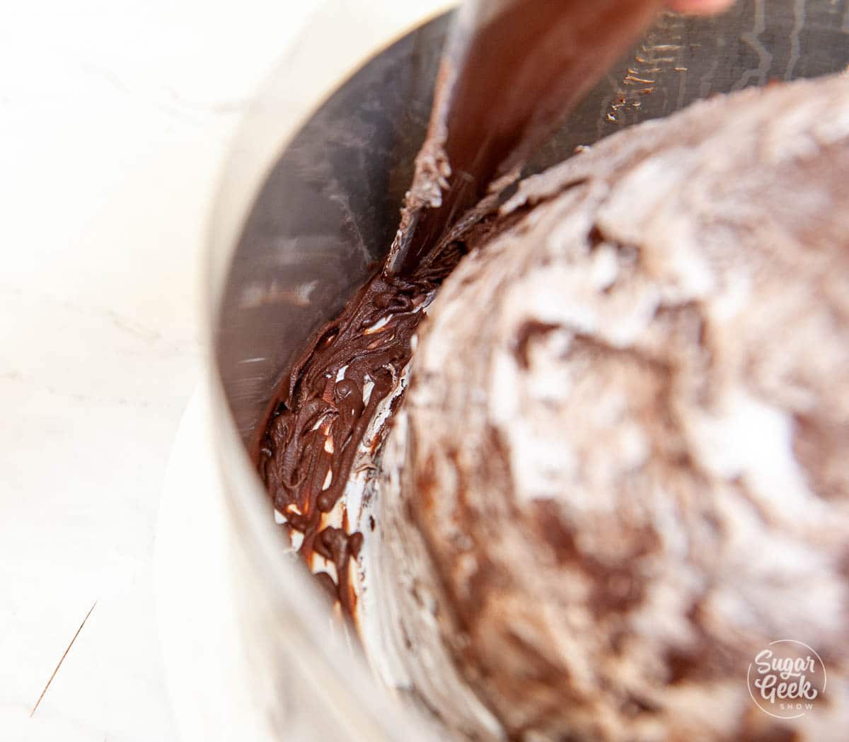 close up of ganache piped on the inside of the cake ring and acetate