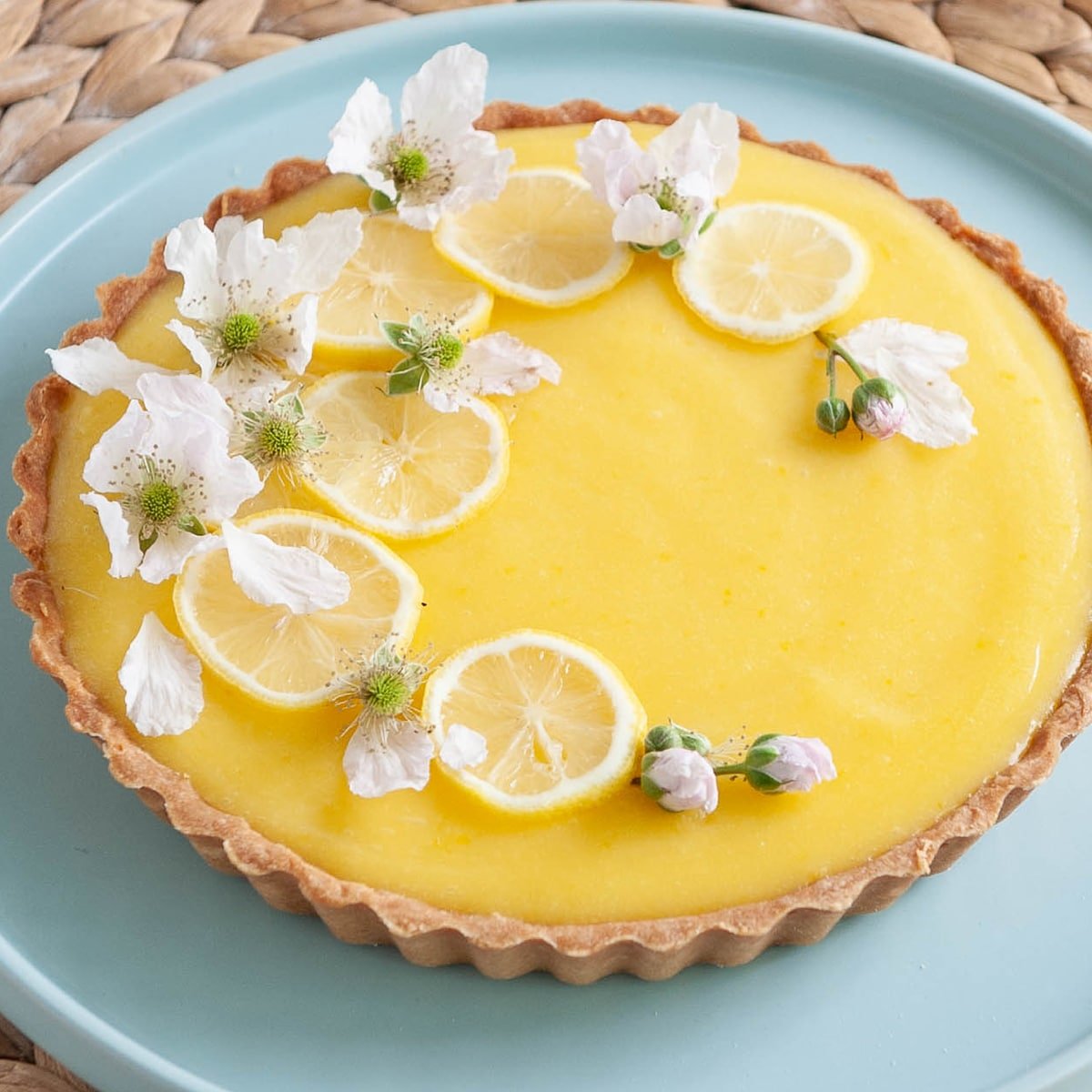 close up of lemon tart on a blue plate