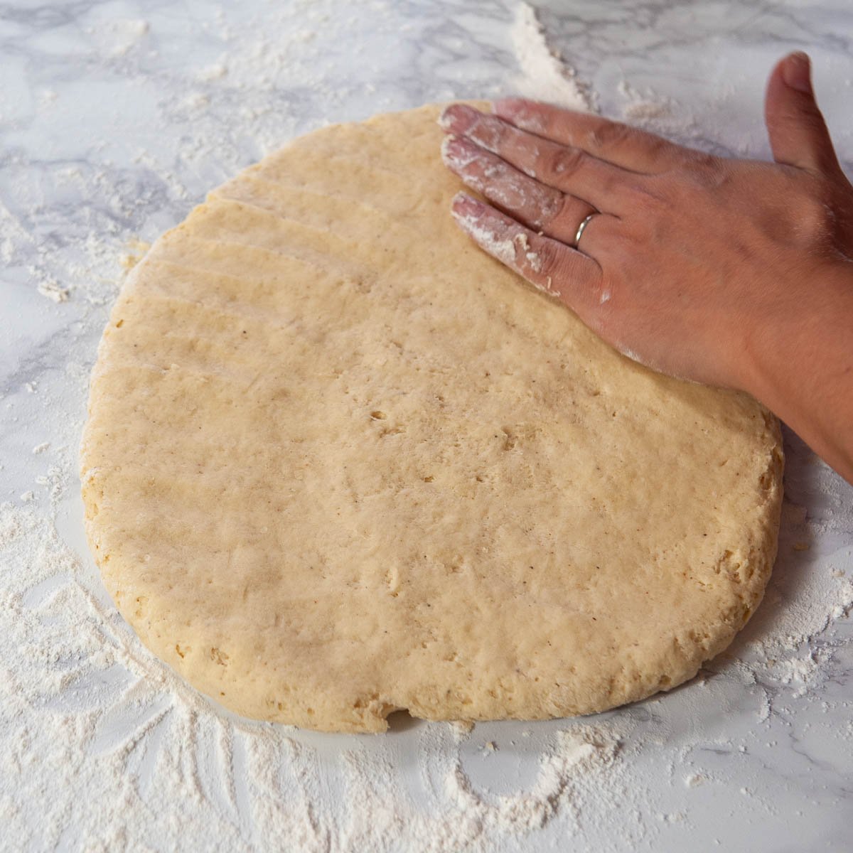 pressing donut dough flat 