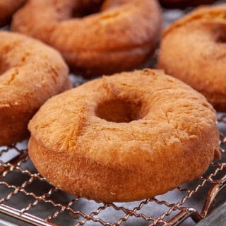 close up of fried cake donut on a cooling rack