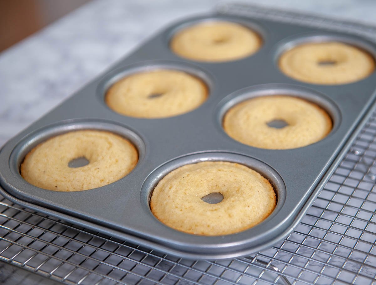 baked donuts in a pan on a cooling rack