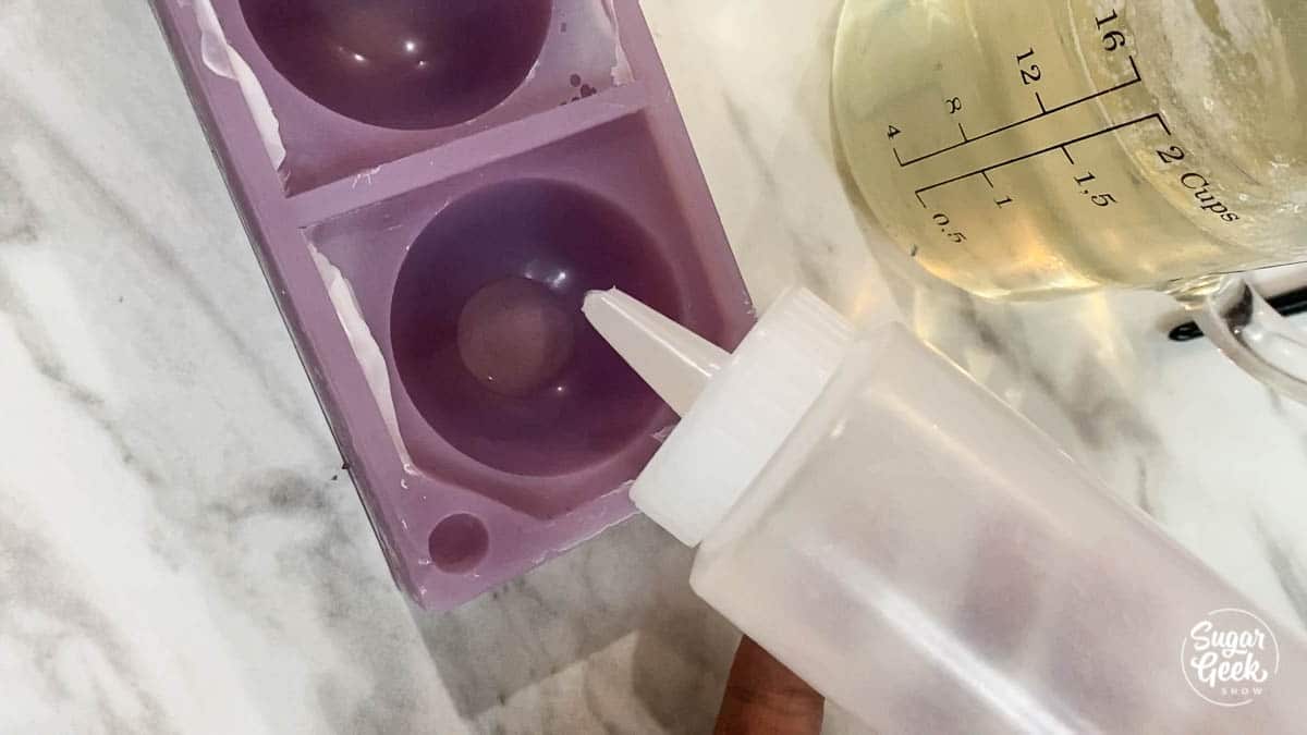 clear plastic bottle over purple silicone sphere mold