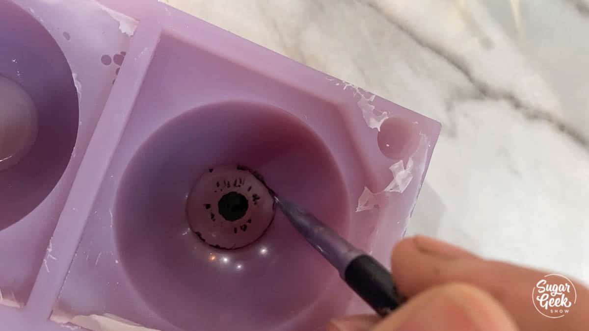 painting details onto gelatin in purple sphere mold