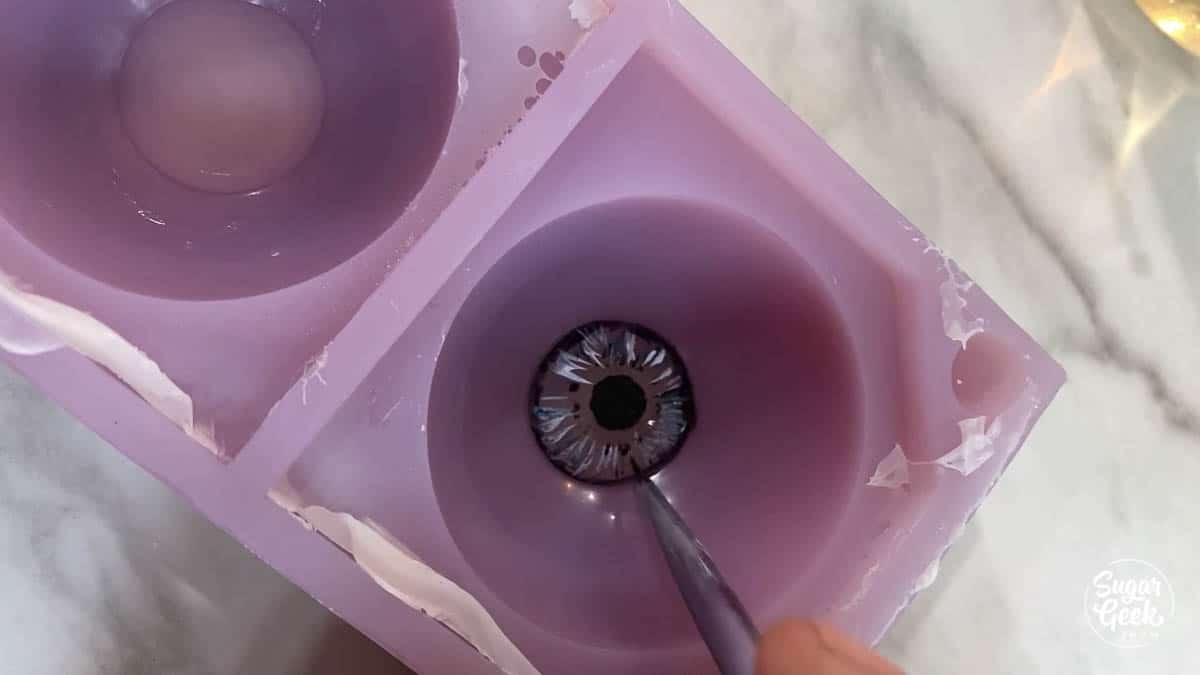 painting details onto gelatin in purple sphere mold