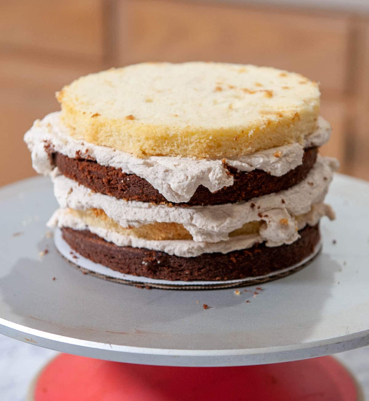 chocolate and vanilla cake with whipped cream on a turntable