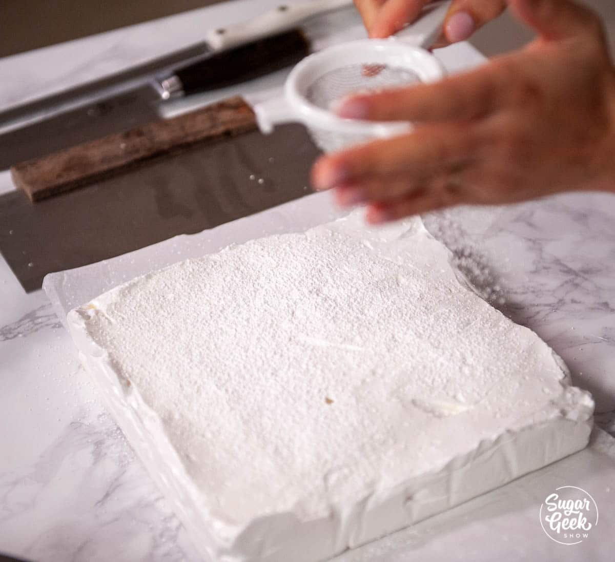 dusting homemade marshmallows with powdered sugar