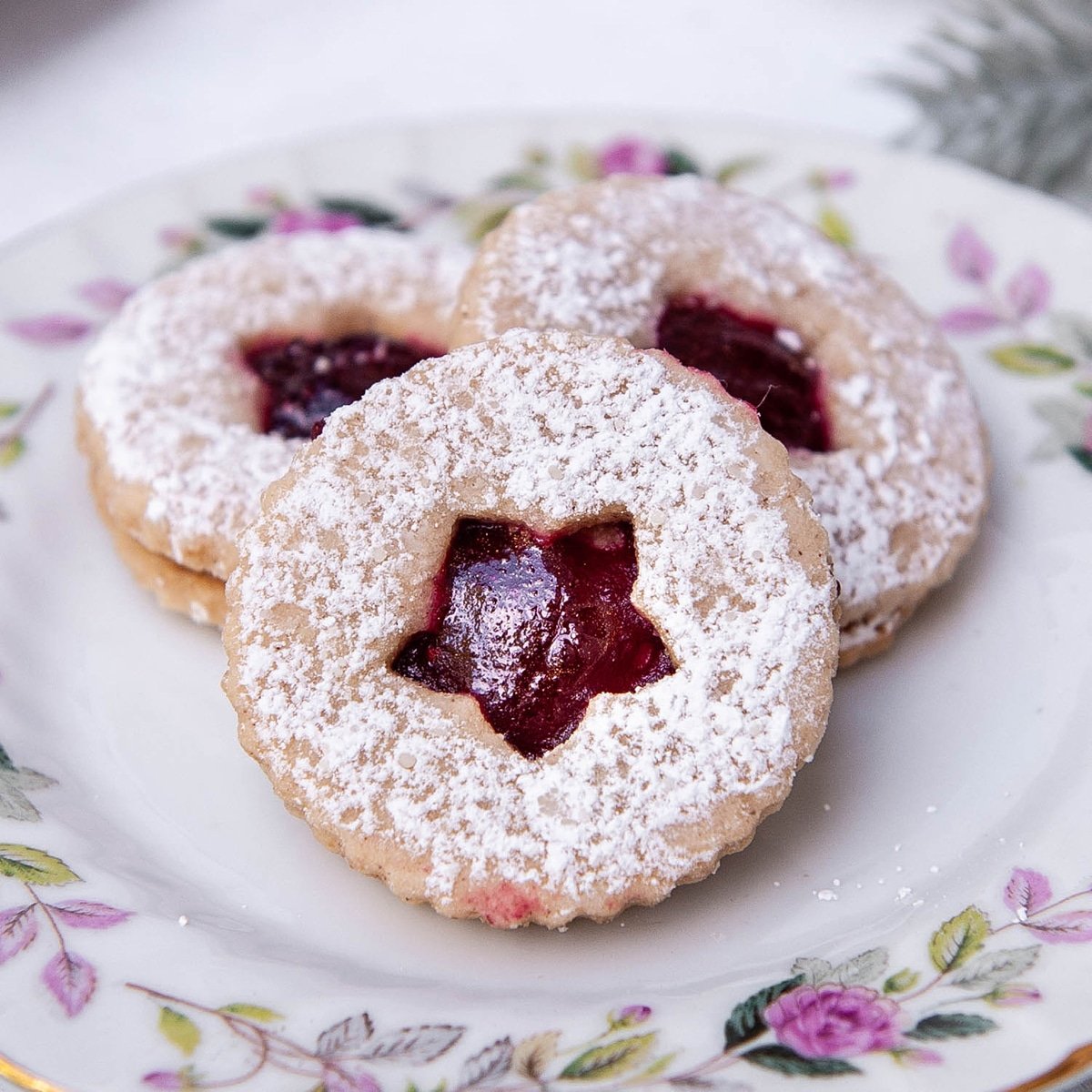 close up of linzer cookies on a floral plate