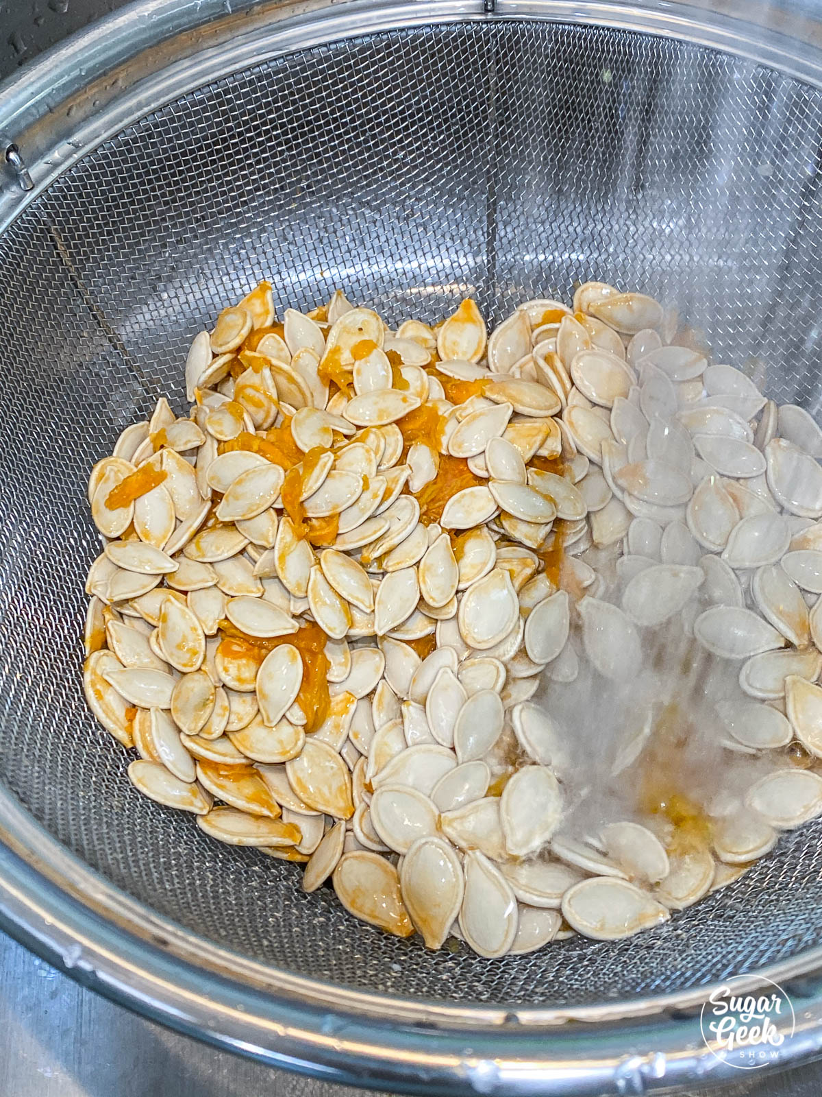 washing pumpkin seeds in a colander