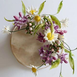 Sugar flowers in an arrangement on top of a cake
