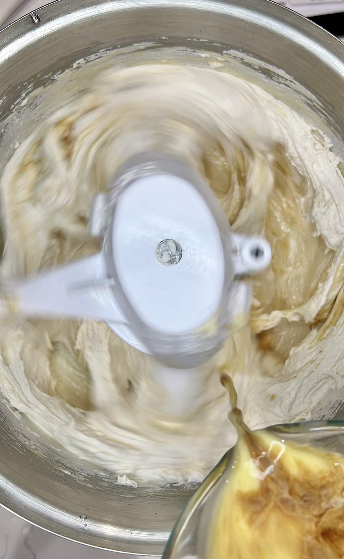 closeup of adding liquids to cake batter